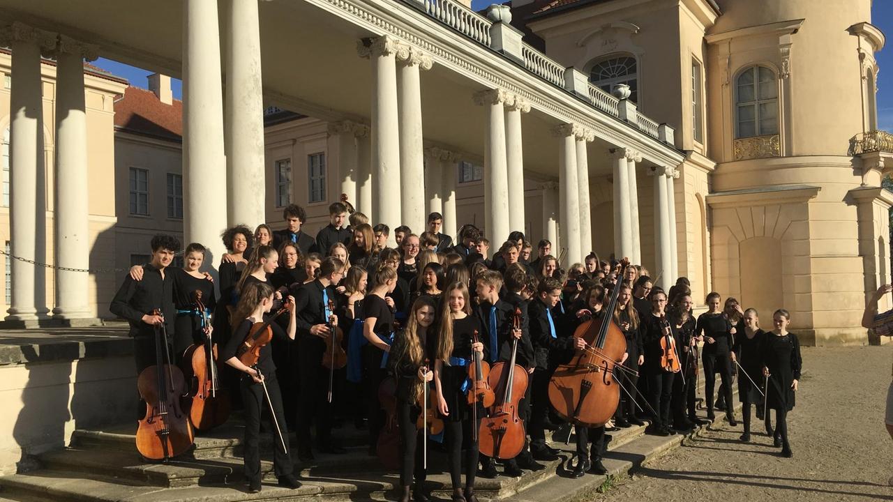 Die Musiker*innen stehen vor den Kolonnaden von Schloss Rheinsberg