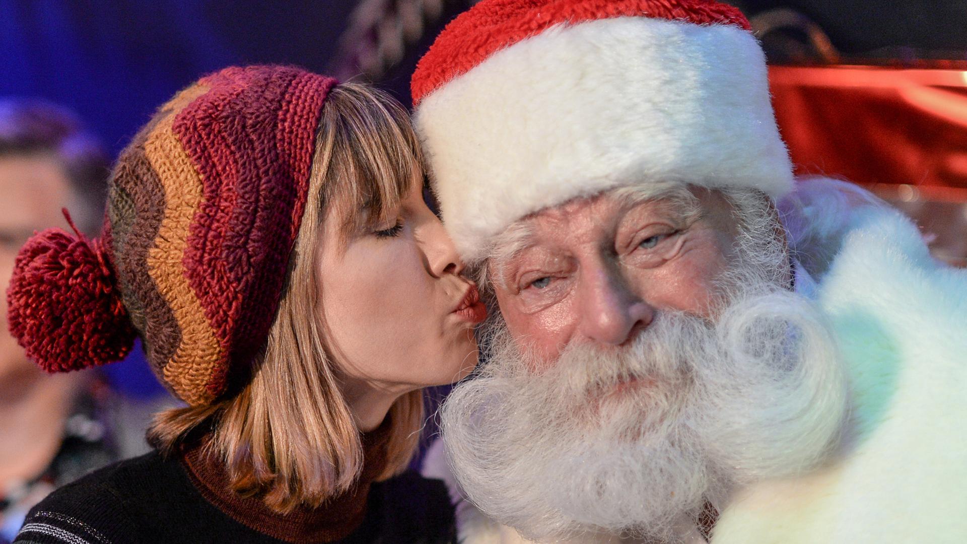 Schauspielerin Isabell Horn küsst bei der Eröffnung des ersten VIP-Weihnachtsmarktes im Wachsfigurenkabinett Madame Tussauds Berlin am 29.11.2017 den Kult-Weihnachtsmann Peter Georgi.