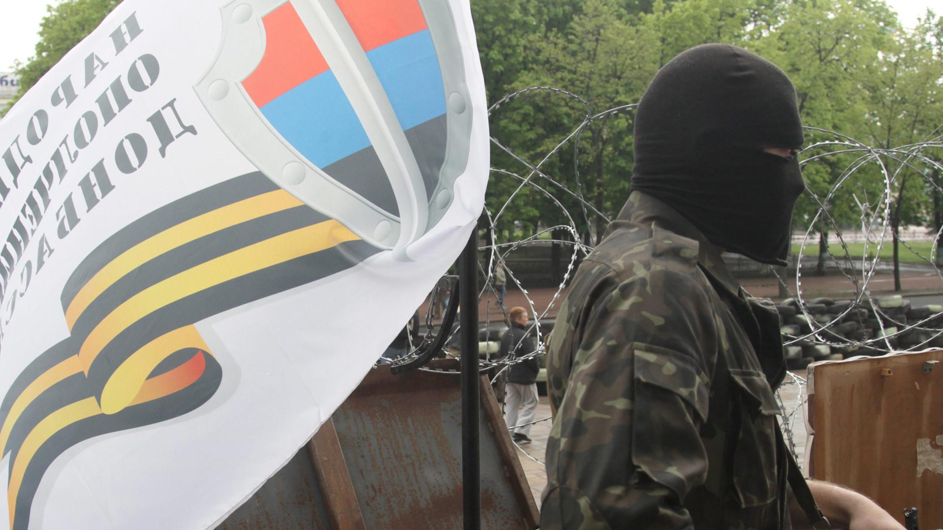 Bewaffneter in Lugansk mit Fahne Bewaffneter in Lugansk mit Fahne