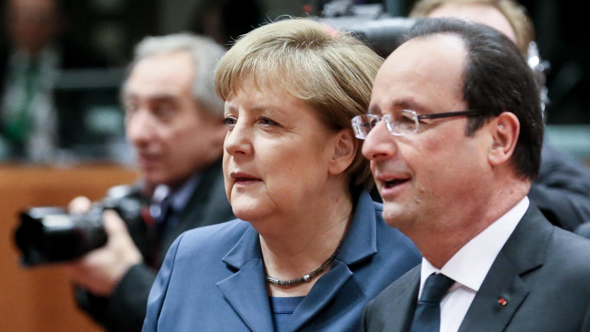 Bundeskanzlerin Angela Merkel und Frankreichs Präsident Francois Hollande unterhalten sich auf dem EU-Gipfel in Brüssel.