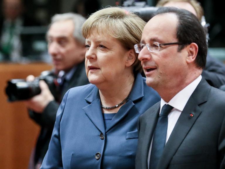 Bundeskanzlerin Angela Merkel und Frankreichs Präsident Francois Hollande unterhalten sich auf dem EU-Gipfel in Brüssel.