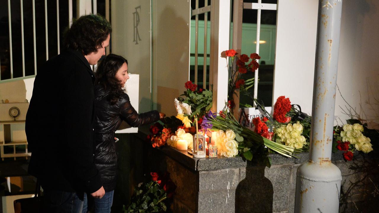 Moskauer Bürger legen Blumen und Kerzen an der französischen Botschaft ab.