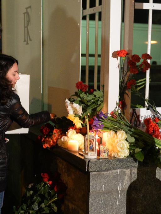 Moskauer Bürger legen Blumen und Kerzen an der französischen Botschaft ab.