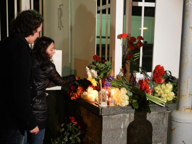 Moskauer Bürger legen Blumen und Kerzen an der französischen Botschaft ab.