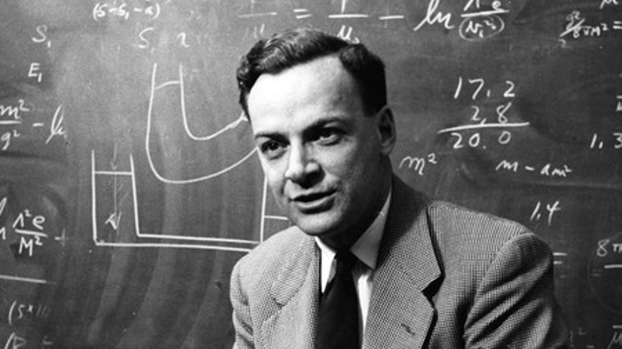 Richard Feynmann vor einer Schiefertafel mit Formeln