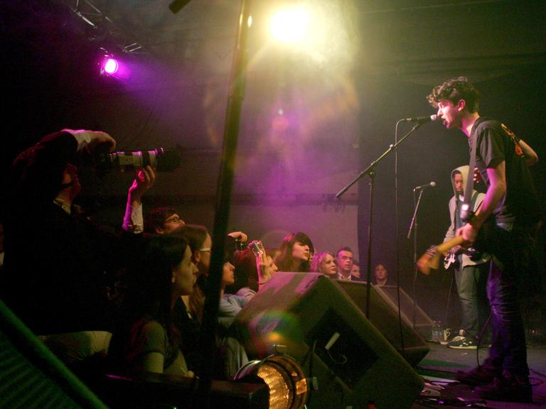 Der Sänger Jamie T. steht auf der Bühne im Gebäude 9 und singt ins Mikrofon, vor ihm das Publikum.