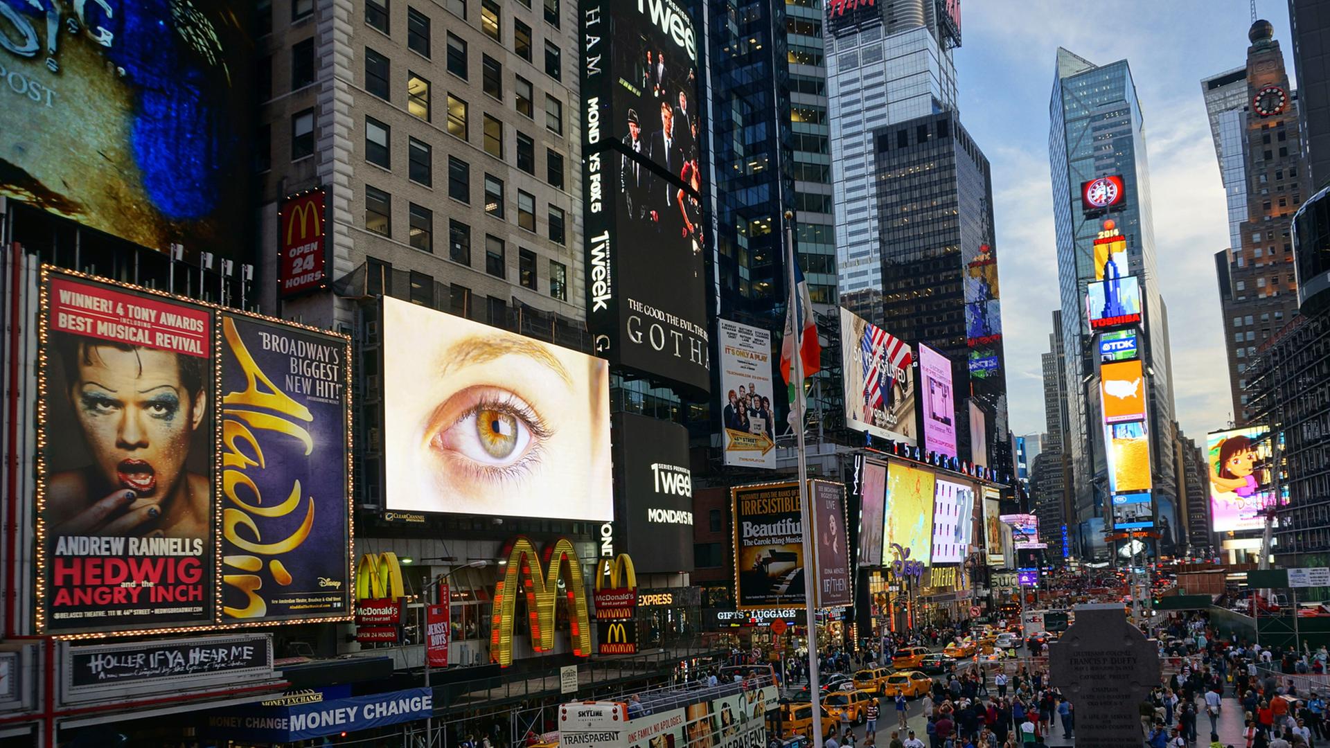Der Times Square in New York mit zahllosen Reklametafeln an Häuserwänden und auf Fahrzeugen.