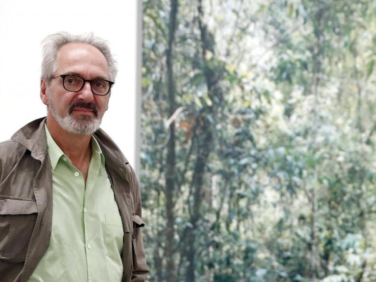 Der Fotograf Thomas Struth steht vor seinem Bild "Paradise 09. XI Shuang Banna, province of Yunnan, China 1999".