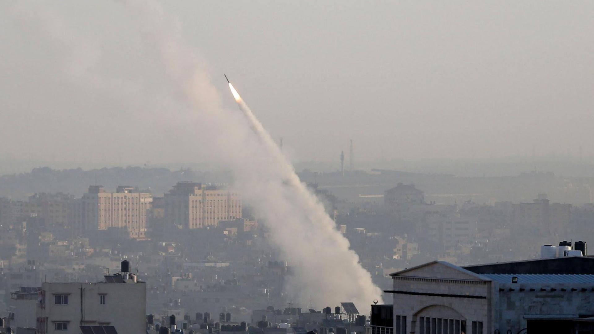 Blick aus der Ferne: Die Rakete schießt mit einem grauen Rauchschweif aus einem Wohngebiet in die Höhe.