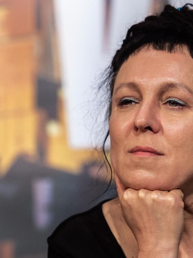 Olga Tokarczuk sitzt auf einem Podium und hört den Fragen zu. Olga Tokarczuk sitzt auf einem Podium und hört den Fragen zu.