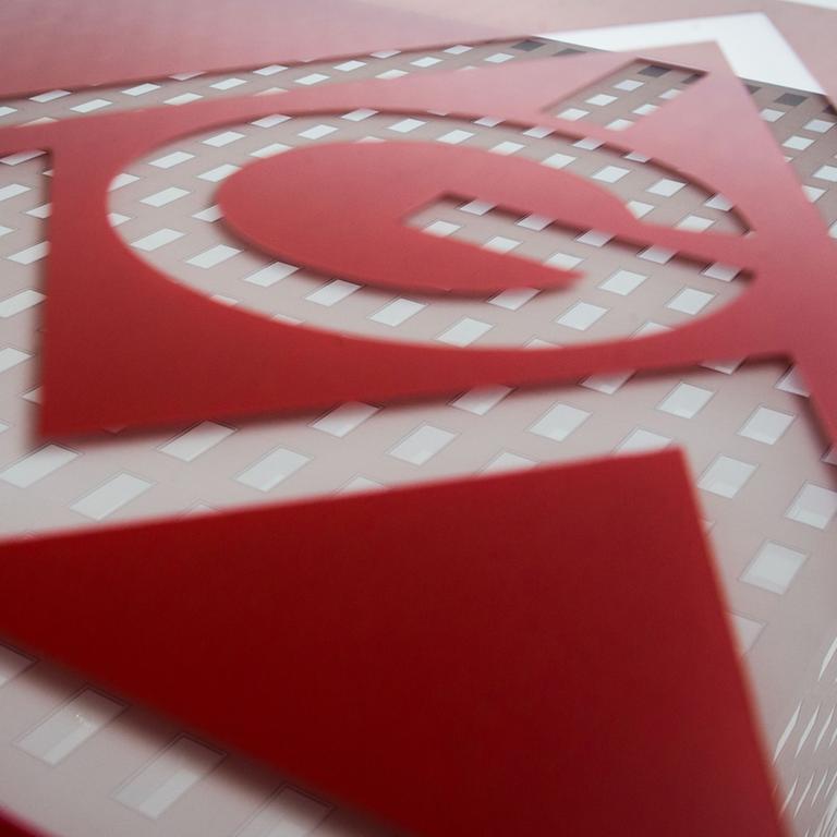 Die Zentrale der IG Metall in Frankfurt am Main spiegelt sich in einem Schild mit dem Logo der Gewerkschaft.