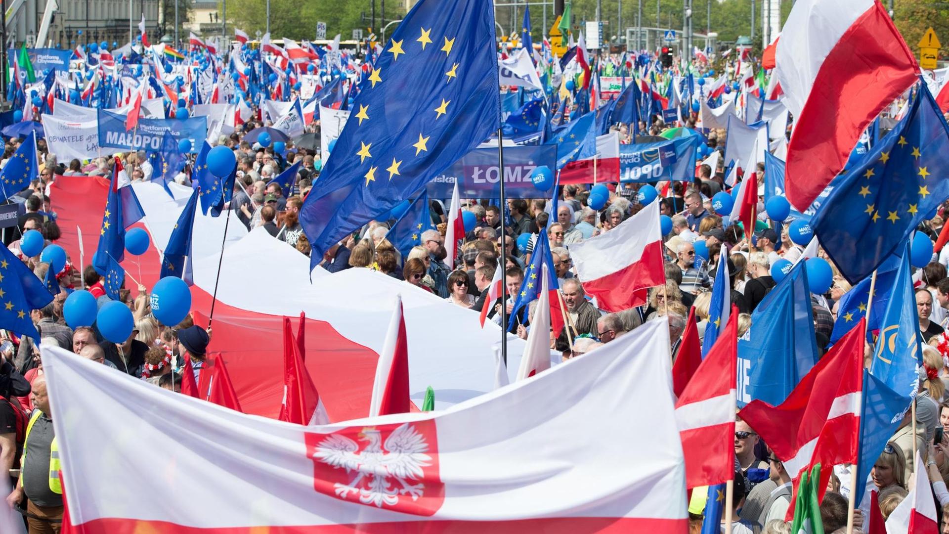 Demonstranten gehen während des Marschs für Freiheit am 06.05.2017 in Warschau mit polnischen und Europaflaggen durch die Innenstadt, um gegen die Regierung und für Europa zu demonstrieren. Der Marsch für die Verteidigung der Freiheit und der europäischen Werte wurde unter anderem von der Oppositionspartei Platforma Obywatelska (Bürgerplattform, PO) organisiert.