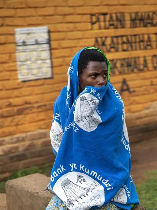 Eine Frau wartet vor einer Klinik in Migowi in Malawi darauf, im Rahmen eines Pilotprojekts der WHO gegen Malaria geimpft zu werden