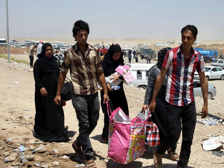 Eine sechsköpfige irakische Familie auf der Flucht vor der Gewalt in Mossul kommt mit einer Tragetasche an einem Checkpoint in Erbil im Nordirak an.