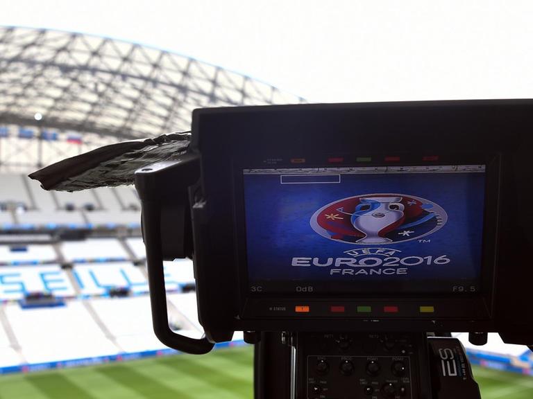 Auf dem Kamera-Bildschirm sieht man das Logo der Europaameisterschaft. Im Hintergrund sieht man eine Tribüne mit der Aufschrift "Marseille". Auf dem Kamera-Bildschirm sieht man das Logo der Europaameisterschaft. Im Hintergrund sieht man eine Tribüne mit der Aufschrift "Marseille".