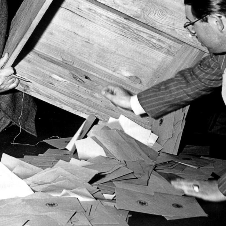 Zwei Wahlhelfer leeren am 14. August 1949 in einem Frankfurter Wahllokal eine Wahlurne zur Stimmauszählung. An diesem Tag fanden in der Bundesrepublik die Wahlen zum ersten Deutschen Bundestag statt.