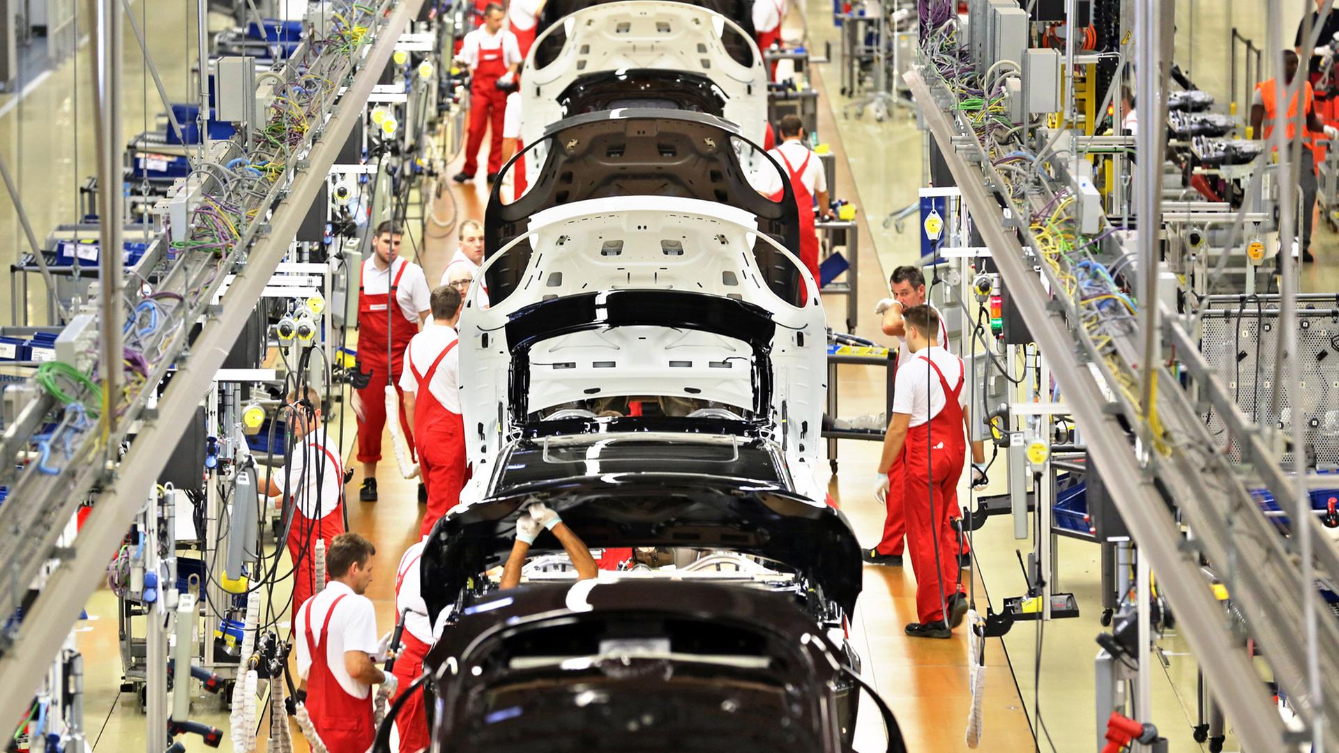 Porsche Mitarbeiter montieren am 04.09.2014 mehrere Panamera in der Produktion der Porsche AG in Leipzig (Sachsen).