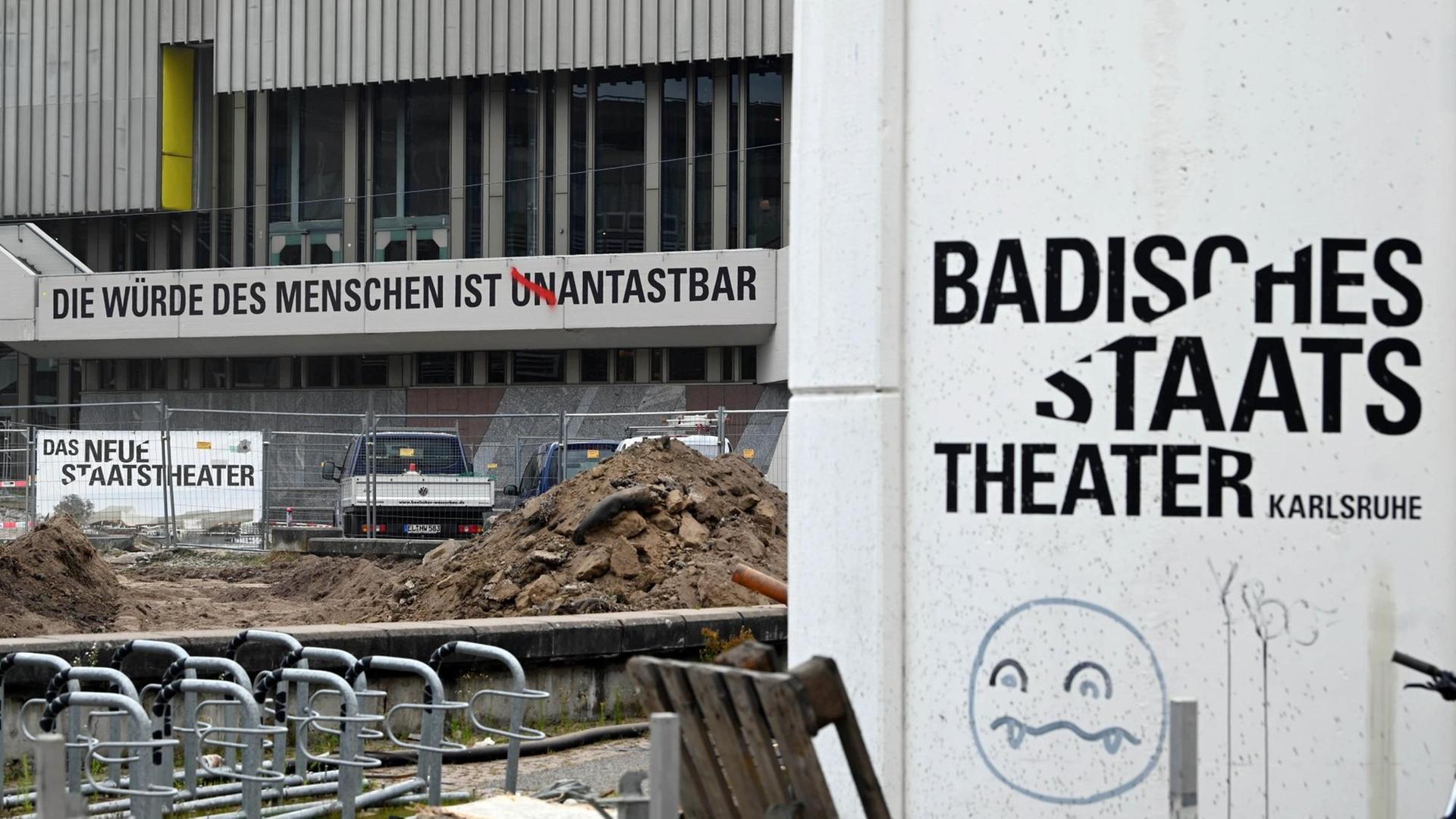 Am Badischen Staatstheater ist der Schriftzug "Die Würde des Menschen ist unantastbar" angebracht. Die Buchstaben UN wurden mit roter Farbe durchgestrichen.