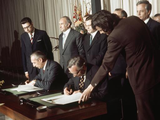 Staatssekretär Günter Gaus (r, Bundesrepublik) und der stellvertretende Außenminister Kurt Nier (l, DDR) unterzeichnen am 14. März 1974 in Bonn das Protokoll über die Errichtung ständiger Vertretungen beider deutscher Staaten. Die Vertretungen nehmen am 2. Mai 1974 ihre Arbeit auf.