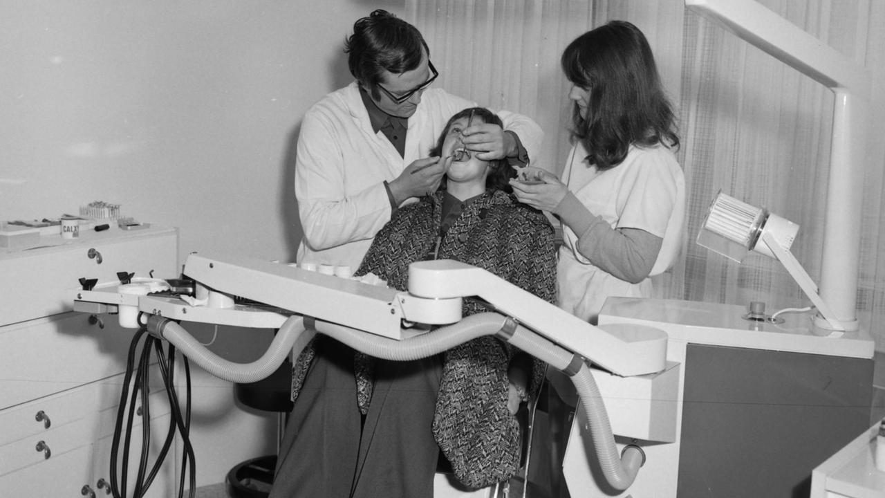 Auf einem Behandlungsstuhl liegend erhält eine Patienten die ärztliche Versorgung für ihre Zähne im Jenaer Universitätshochhaus 1976.