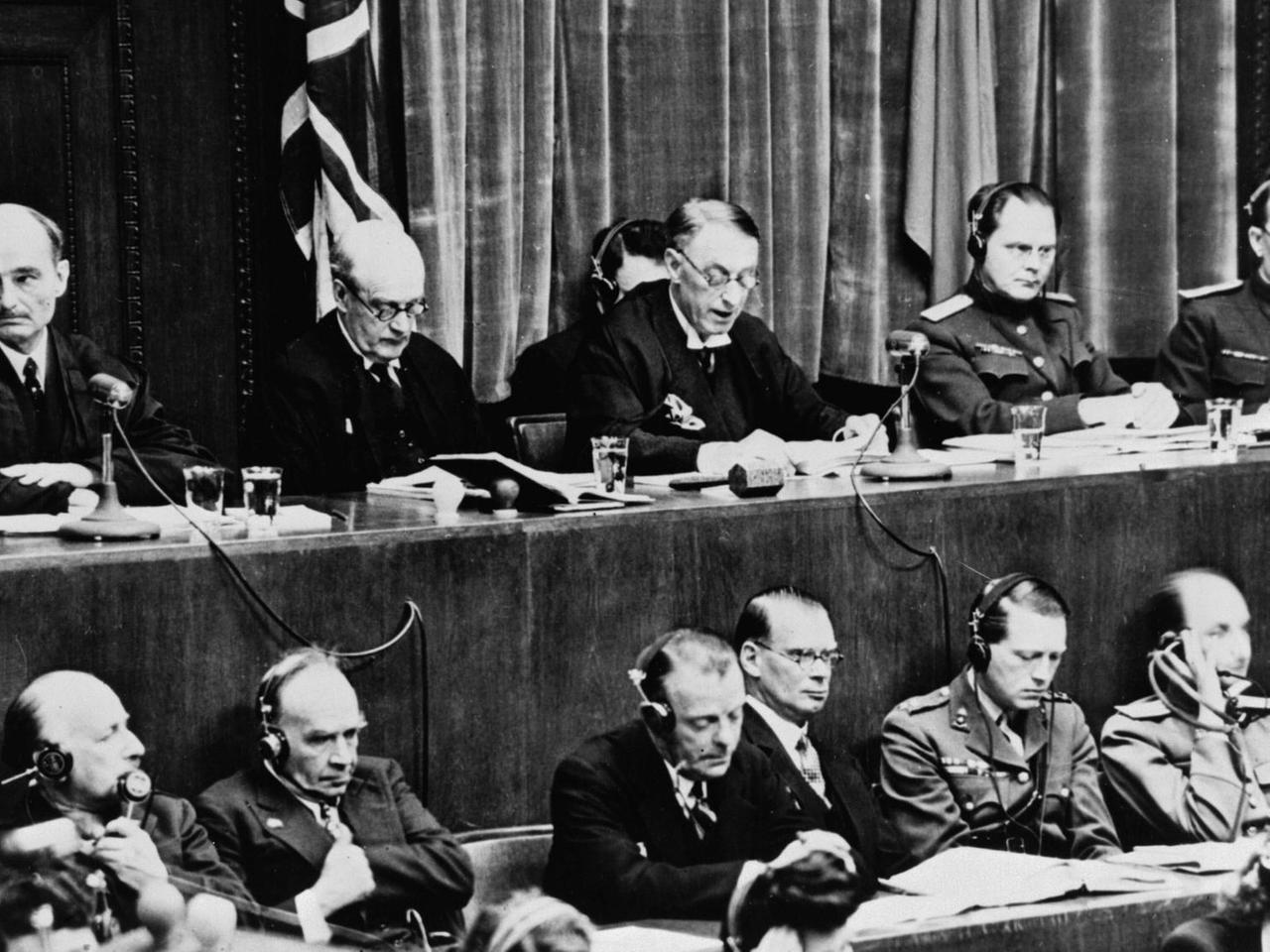 Blick auf die Richterbank im Nürnberger Justizpalast während der Verlesung der Urteilsbegründung, v.l.n.r.: Wolchkow, Nikitschenko (UdSSR), Birkett, Lawrence (GB) und Biddle (USA) Blick auf die Richterbank im Nürnberger Justizpalast während der Verlesung der Urteilsbegründung, v.l.n.r.: Wolchkow, Nikitschenko (UdSSR), Birkett, Lawrence (GB) und Biddle (USA)