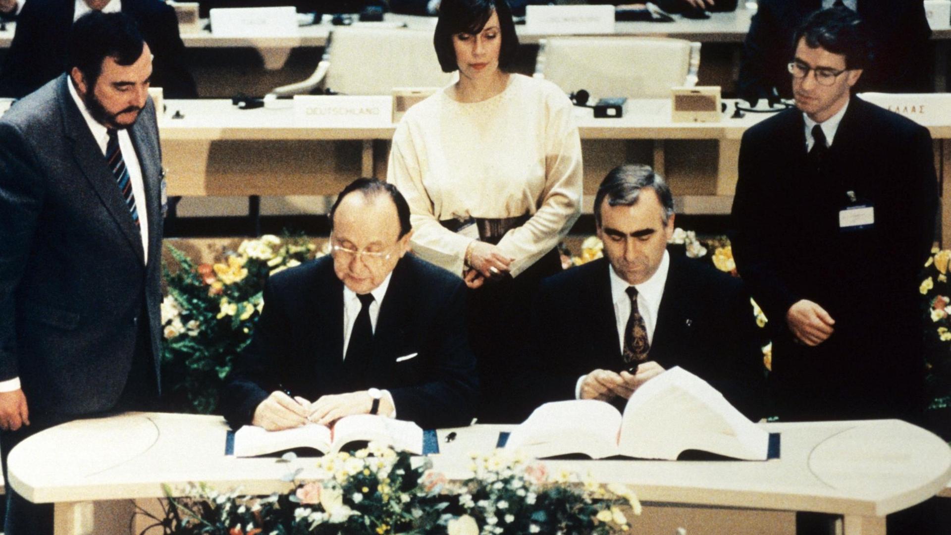 Hans-Dietrich Genscher (links) und Theo Waigel (rechts) unterzeichnen am 7. Februar 1992 den Vertrag zur Wirtschafts- und Währungsunion der Europäischen Gemeinschaft in Maastricht (Niederlande).