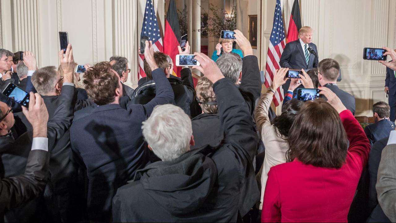 Journalisten fotografieren US-Präsident Donald Trump und Bundeskanzlerin Angela Merkel mit ihren Smartphones.