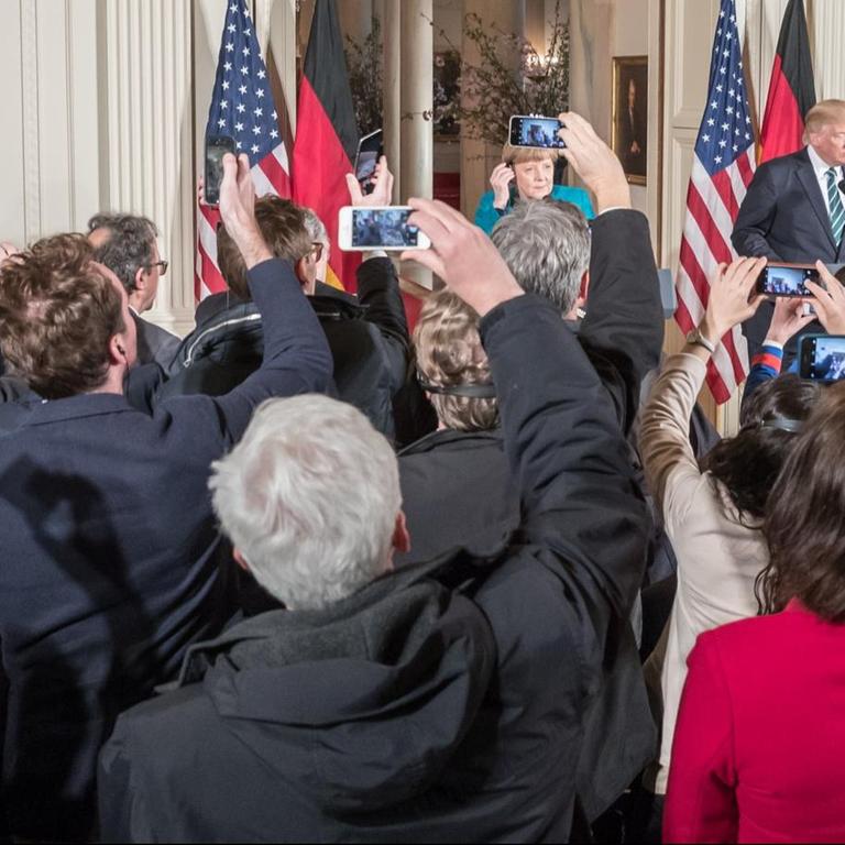 Journalisten fotografieren US-Präsident Donald Trump und Bundeskanzlerin Angela Merkel mit ihren Smartphones. 