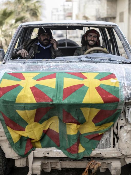 Zwei Kurden in einem kaputten Auto in Kobane