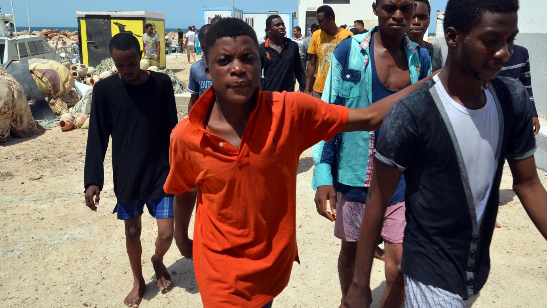 Migranten aus Subsahara-Afrika kommen im Hafen der tunesischen Stadt Ben Guerdane an, nachdem sie von der tunesischen Küstenwache aus dem Mittelmeer vor Libyen gerettet wurden