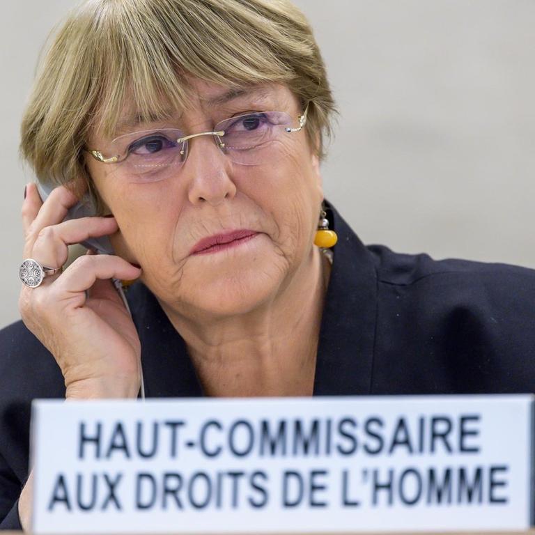 UNO-Hochkommissarin für Menschenrechte, Michelle Bachelet, sitzt an einem Schreibtisch und telefoniert mit einem Handy.