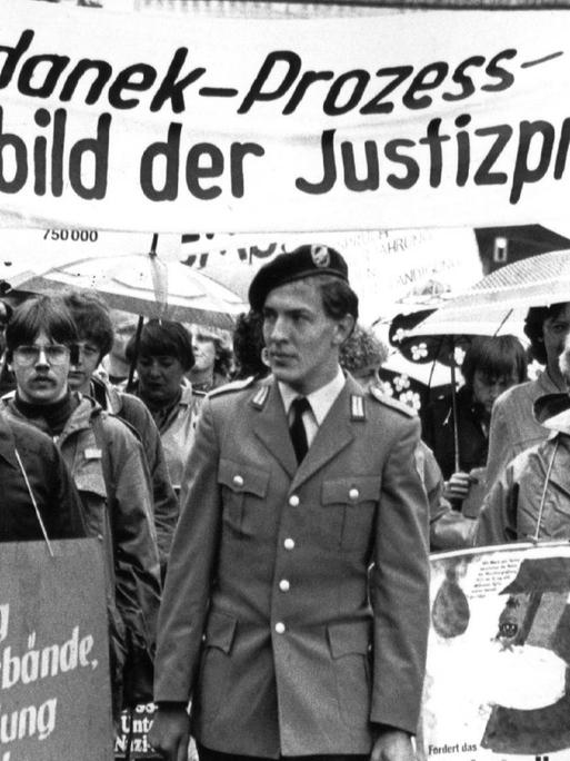 Demonstration vor der Urteilsverkündung im Majdanek-Prozess: Menschen mit einem Banner: "Der Majdanek-Prozess - Jammerbild der Justizpraxis"