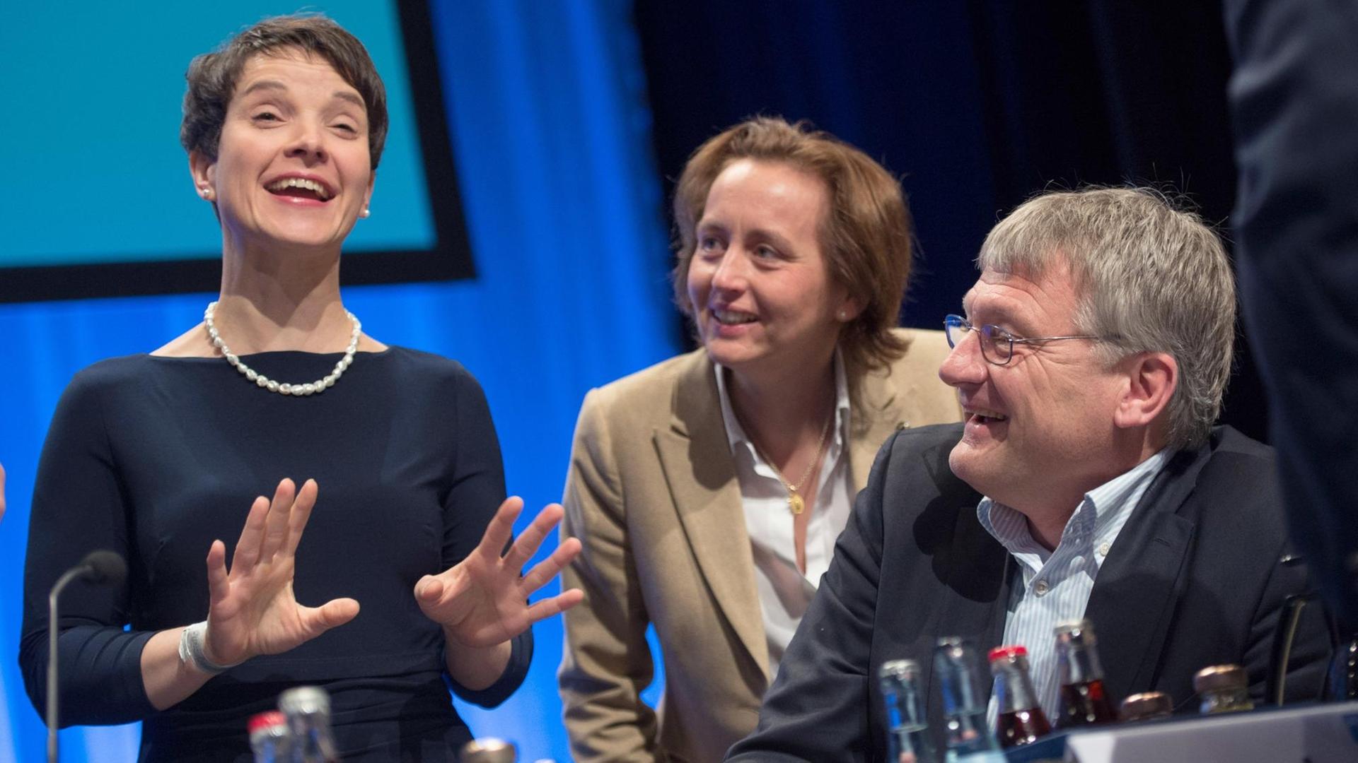 Frauke Petry, Beatrix von Storch und Jörg Meuthen unterhalten sich auf dem AfD-Parteitag, alle drei lächeln.