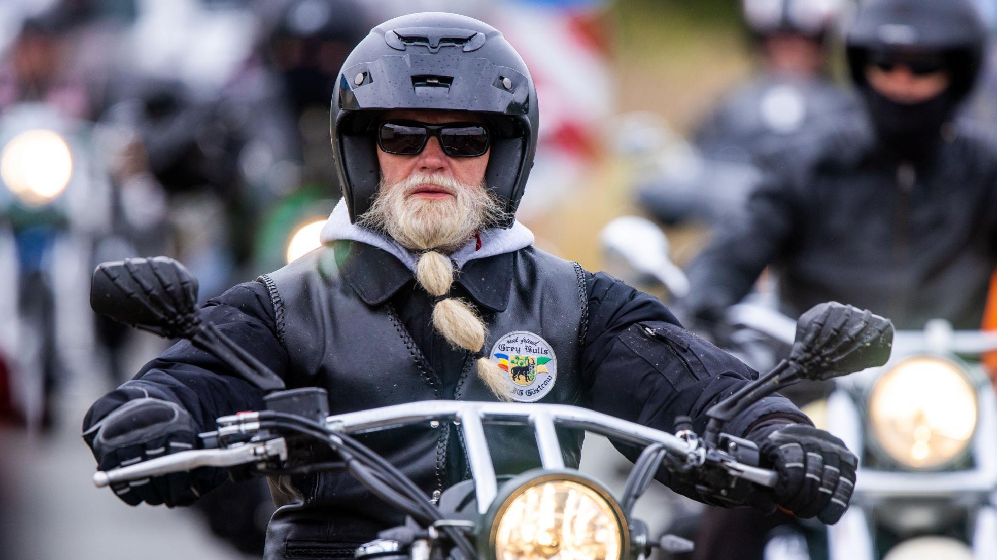 Mann in einem motorrad mit sturzhelm und handschuhen ist