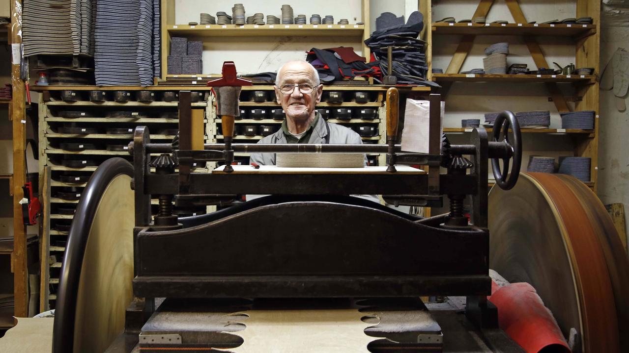 Pantoffeleck in Berlin-Mitte: Günter Jünemann (75) an der Stanzmaschine, dort werden die Sohlen ausgestanzt. Pantoffeleck in Berlin-Mitte: Günter Jünemann (75) an der Stanzmaschine, dort werden die Sohlen ausgestanzt.