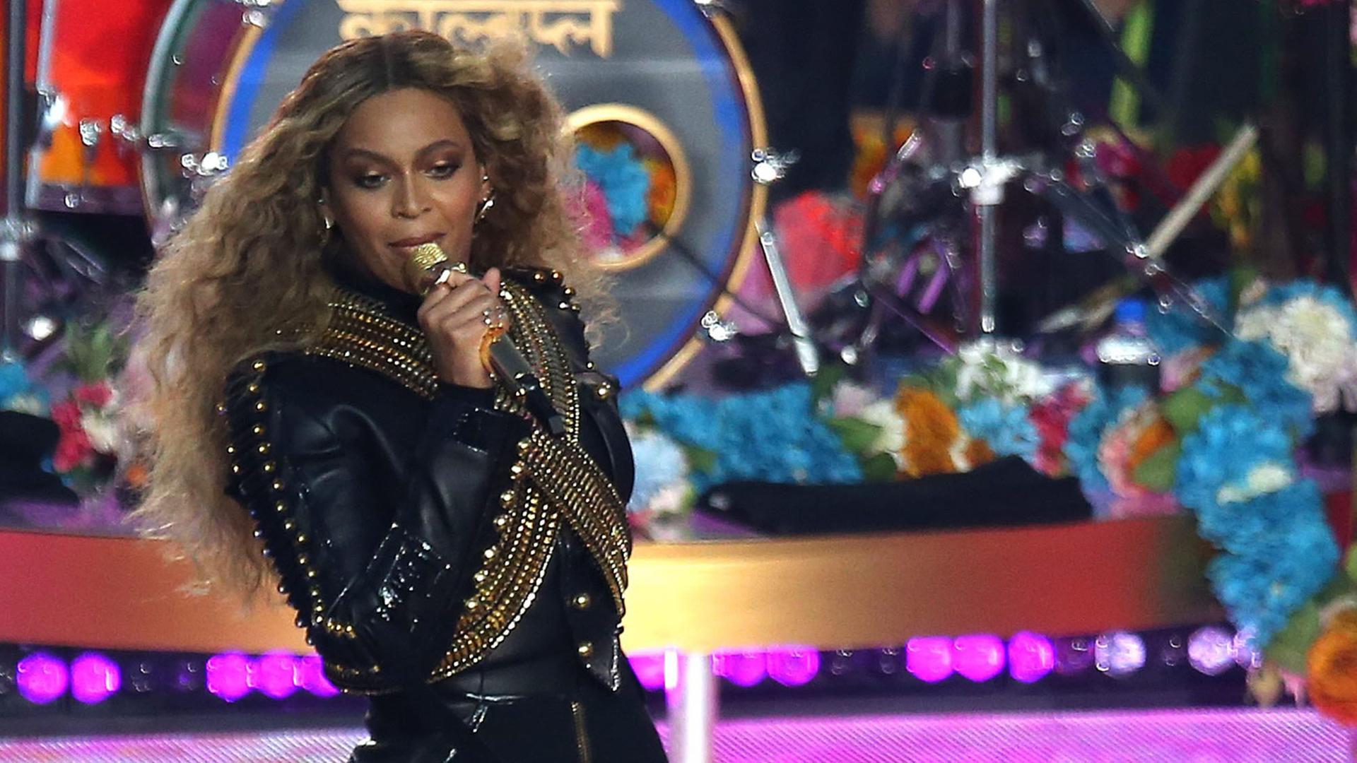 Die US-Sängerin Beyoncé steht bei ihrem Auftritt beim Super Bowl mit Mikrofon auf einer Bühne