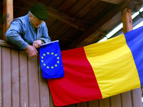 Ein Rumäne hängt eine EU-Flagge neben eine Rumänien-Fahne: Rumänien tritt am 1. Januar 2007 der EU bei.