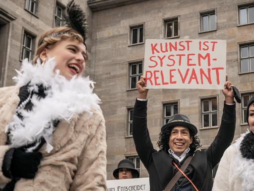 Künstler demonstrieren für wirksame Corona-Hilfen für Soloselbstständige vor dem Finanzministerium mit Schildern, unter anderem mit der Aufschrift „Kunst ist systemrelevant“.