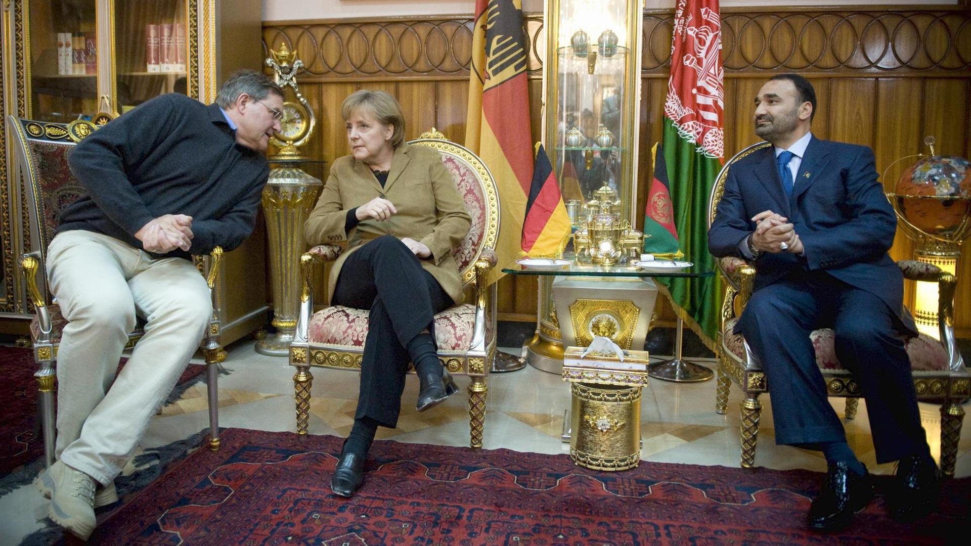 Bundeskanzlerin Angela Merkel am 06.04.2009 in Masar-i-Sharif in Afghanistan während eines Treffens mit dem Provinzgouverneur von Balkh, Mohammad Atta und Bundesverteidigungsminister Franz Josef Jung.