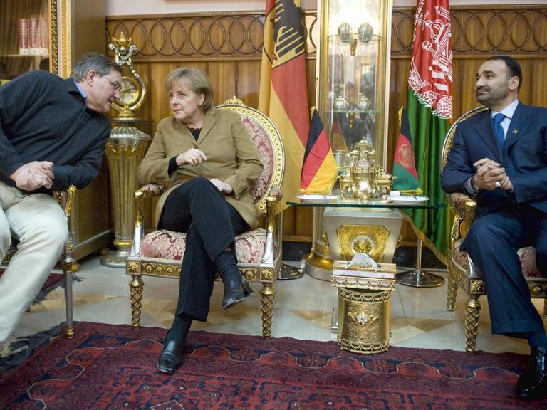 Bundeskanzlerin Angela Merkel am 06.04.2009 in Masar-i-Sharif in Afghanistan während eines Treffens mit dem Provinzgouverneur von Balkh, Mohammad Atta und Bundesverteidigungsminister Franz Josef Jung.