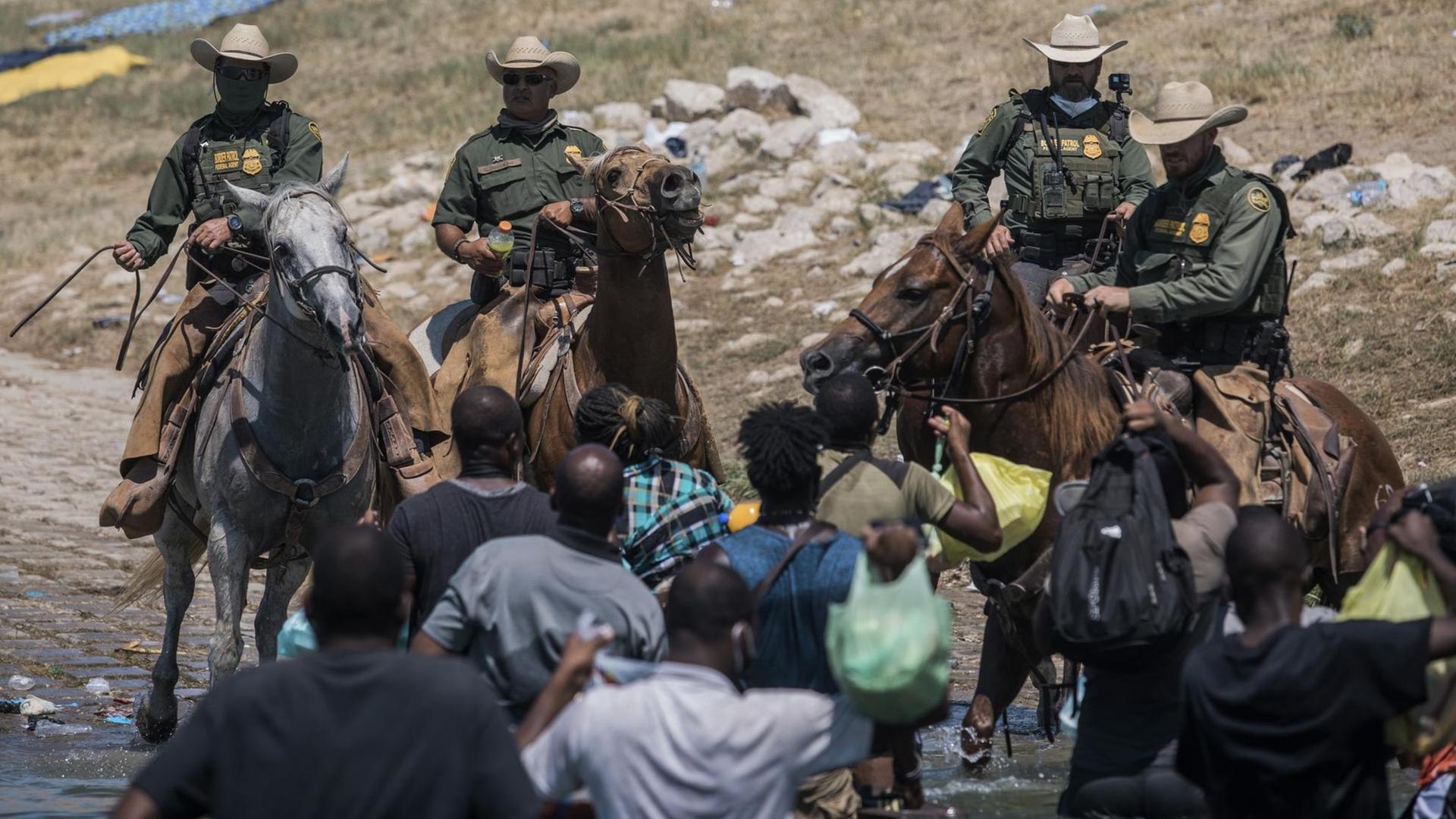 Beamte der US-Zoll- und Grenzschutzbehörde versuchen, Migranten bei der Überquerung des Rio Grande in Texas aufzuhalten.