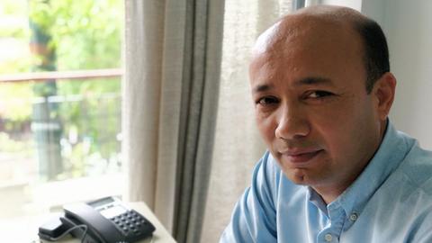 Yonous Muhammadi sitzt in seinen Büro an einem Schreibtisch