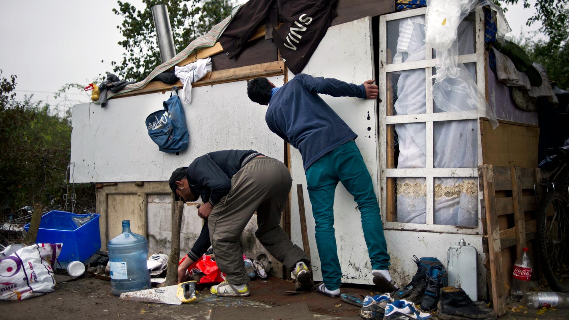 Zwei junge Roma basteln eine Tür für ihre Behelfshütte in einem Lager östlich von Paris im Oktober 2012.
