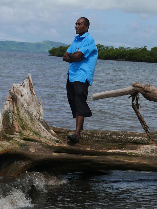 Sailosi Ramatu, Oberhaupt des Dorfs Vunidogoloa auf den Fidschi-Inseln, steht auf einem umgefallenen Baum am Strand.