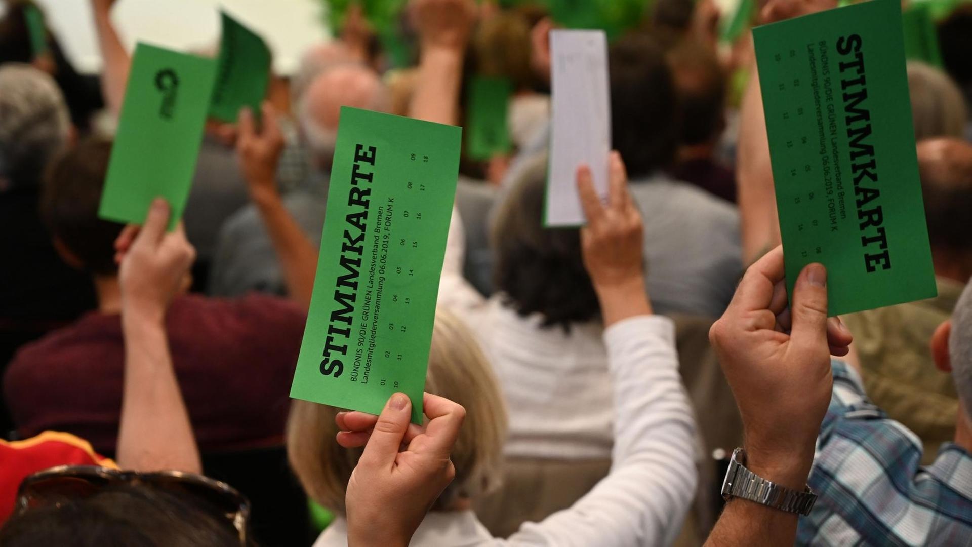 Bei einer Abstimmung werden grüne Abstimmungs-Karten hochgehalten
