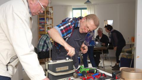 Ein Mann repariert ein altes Radio.