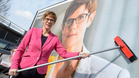 Die saarländische Ministerpräsidentin Annegret Kramp-Karrenbauer (CDU) klebt am 09.02.2017 in Saarbrücken mit einem Besen symbolisch das letzte Teil ihres Plakatmotivs für die Landtagswahl an, das sie zuvor enthüllte.