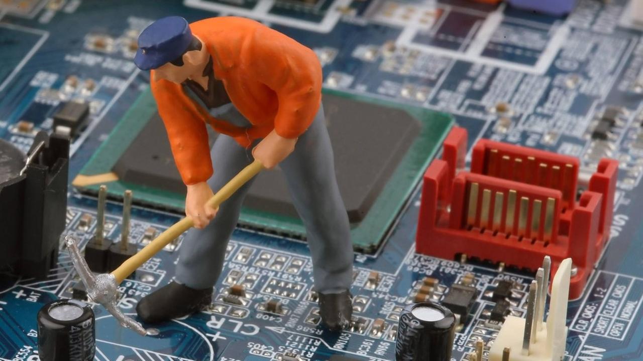 Die Spielfigur eines Bauarbeiters steht auf einer Computerplatine