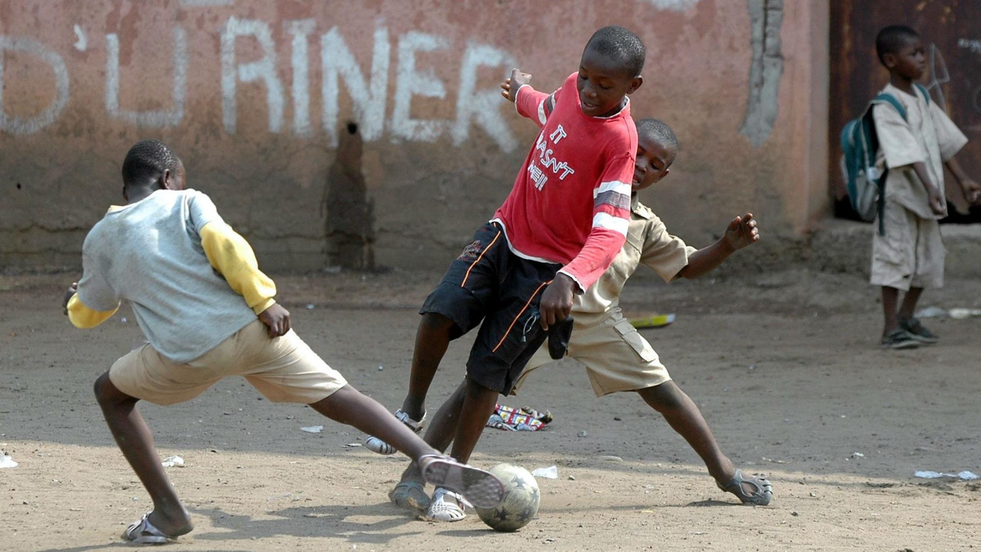 Zwei Jungen spielen Straßenfußball im Attiekoube Slum in Abidjan, der Hauptstadt der Elfenbeinküste.
