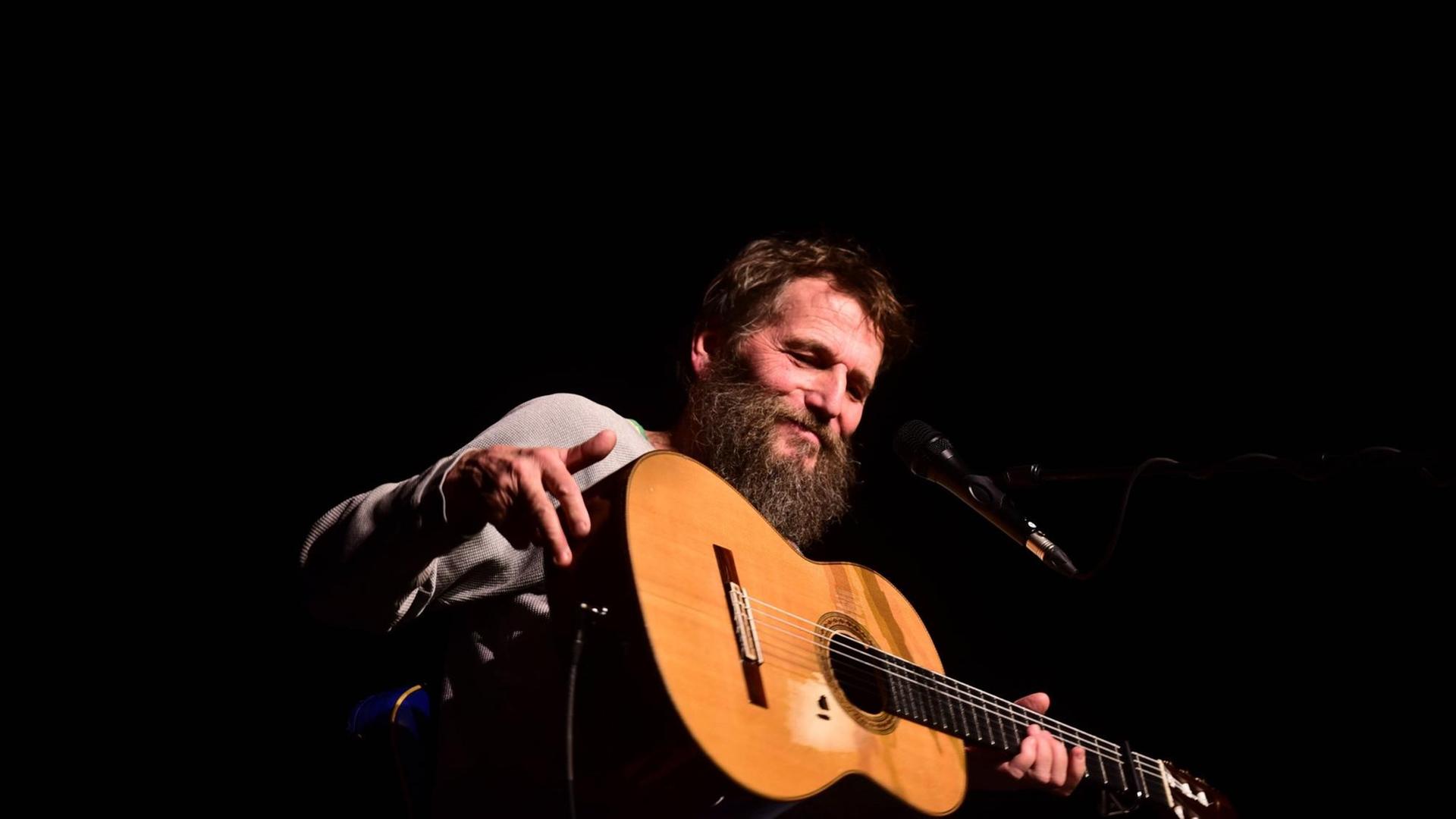 Hans Söllner mit Gitarre auf einer Bühne in Salzburg.